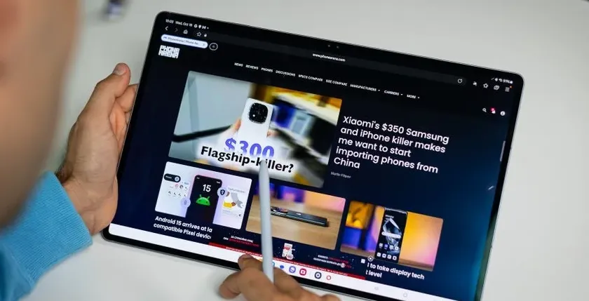 Person using a stylus on a Samsung Galaxy Tab while browsing a tech website