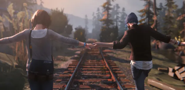 Dua karakter Max dan Chloe berjalan di rel kereta api sambil berpegangan tangan di area hutan