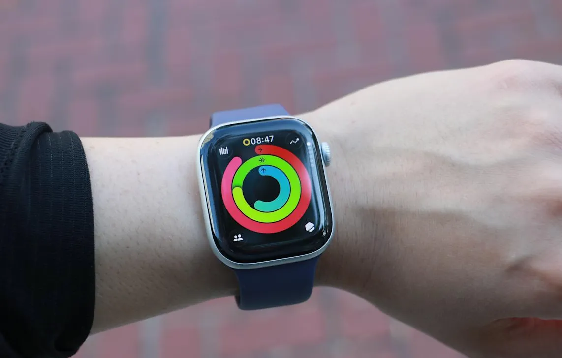 Apple Watch Series 11 menampilkan activity rings watchOS 26 pada pergelangan tangan pengguna.