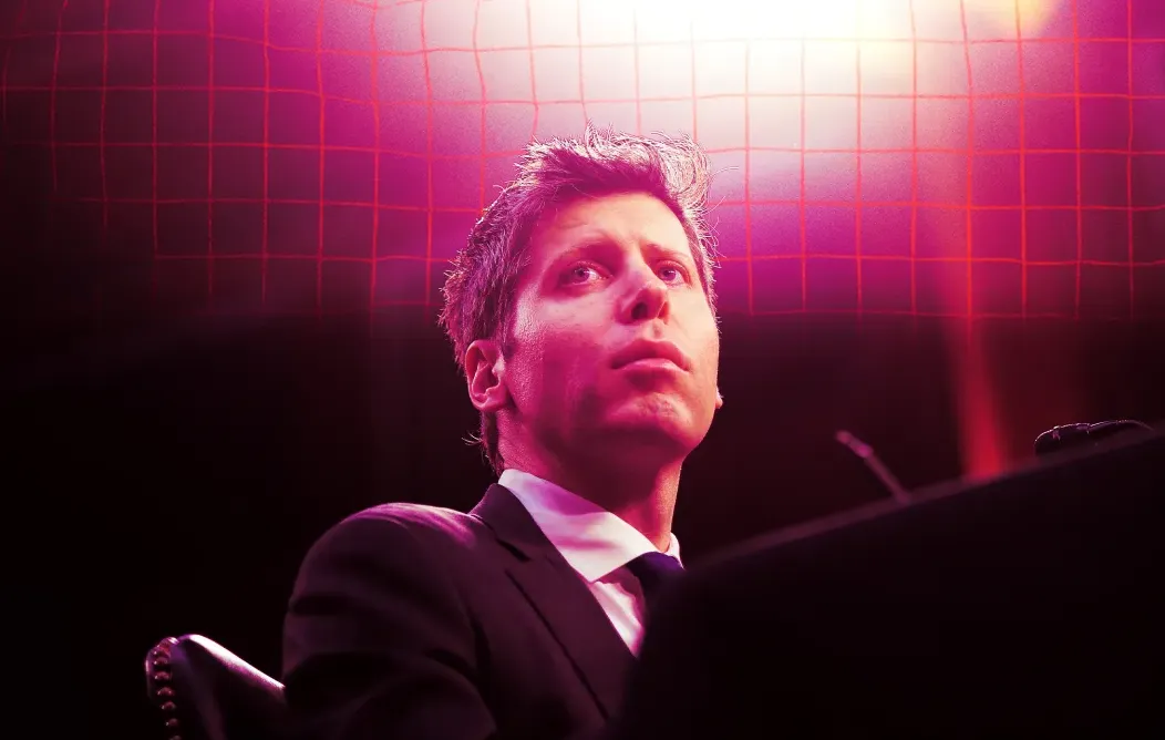 Sam Altman CEO OpenAI duduk dengan ekspresi serius di depan latar belakang cahaya merah muda dan ungu.