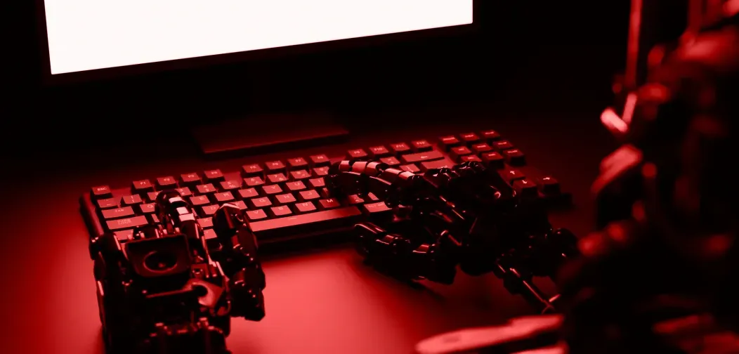 Tangan robot di atas keyboard komputer dengan cahaya merah