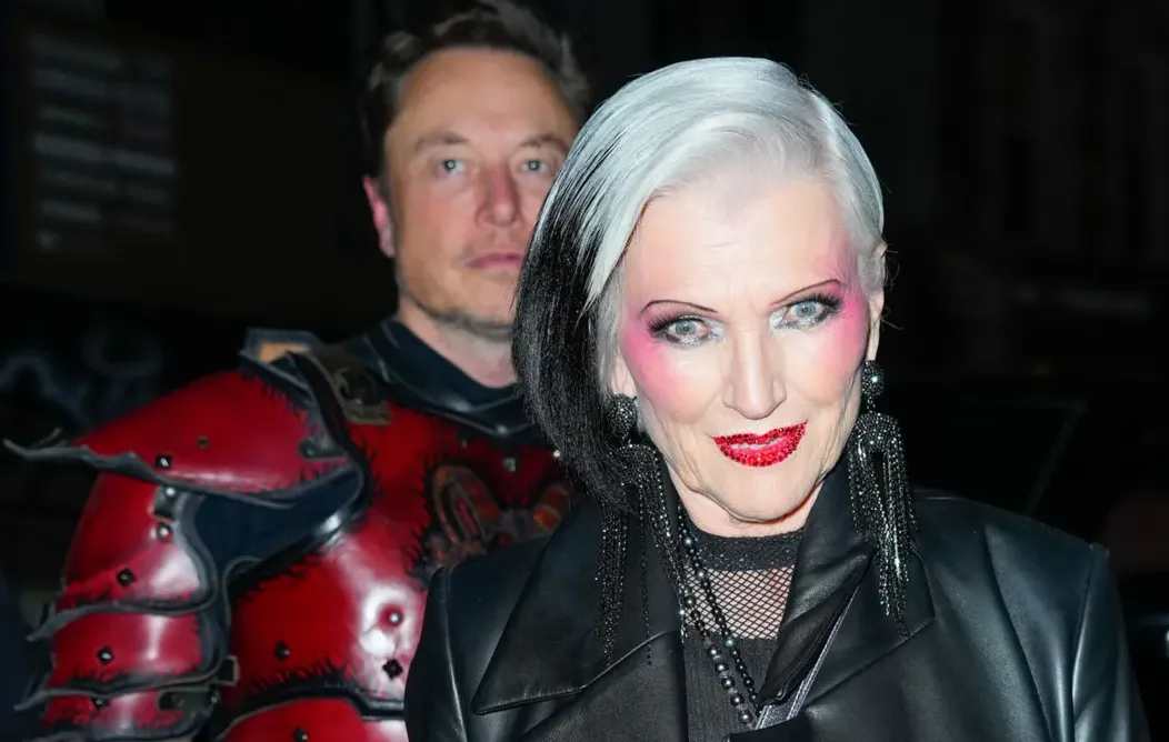 Maye Musk and Elon Musk in costume at an event with dark background