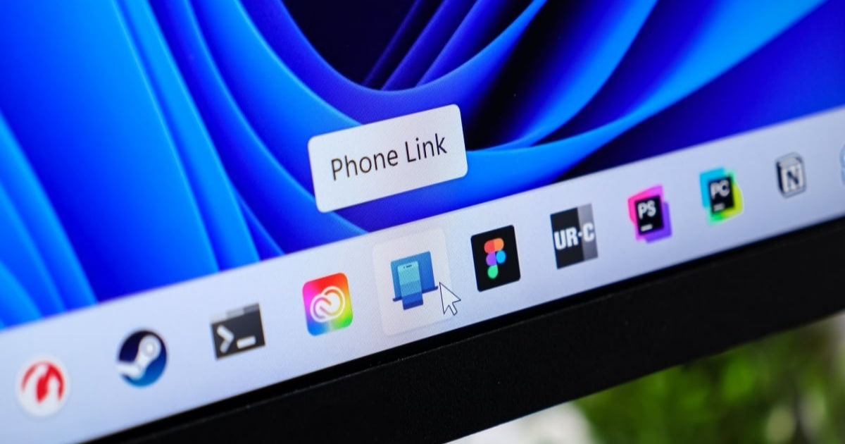 Ilustrasi iPhone terhubung ke laptop Windows melalui aplikasi Phone Link untuk mengakses iMessage
