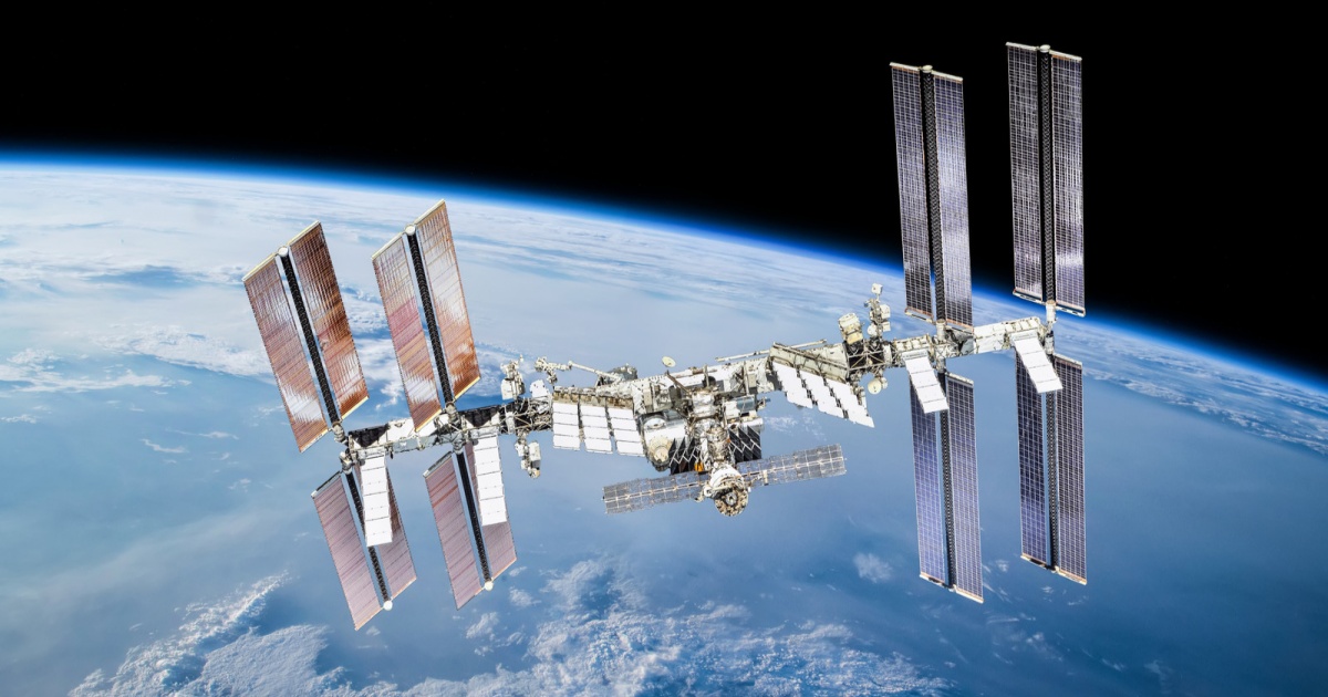 Ilustrasi Stasiun Luar Angkasa Internasional ISS mengorbit Bumi dengan latar belakang matahari