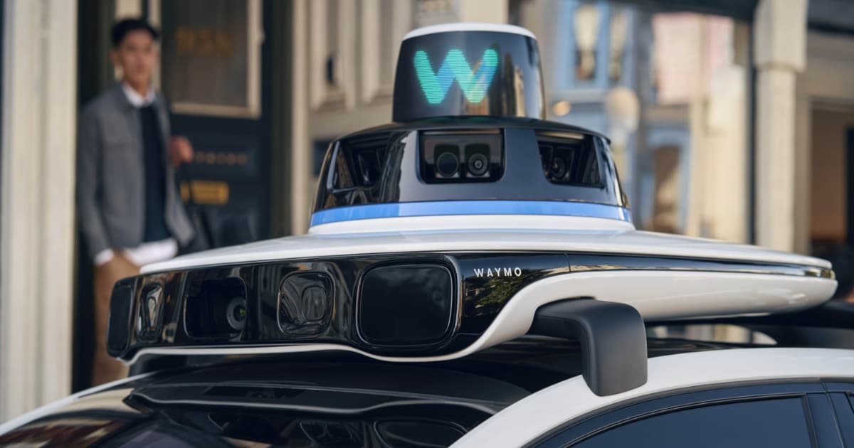 Sensor panel di atas mobil otonom Waymo dengan penumpang di latar belakang