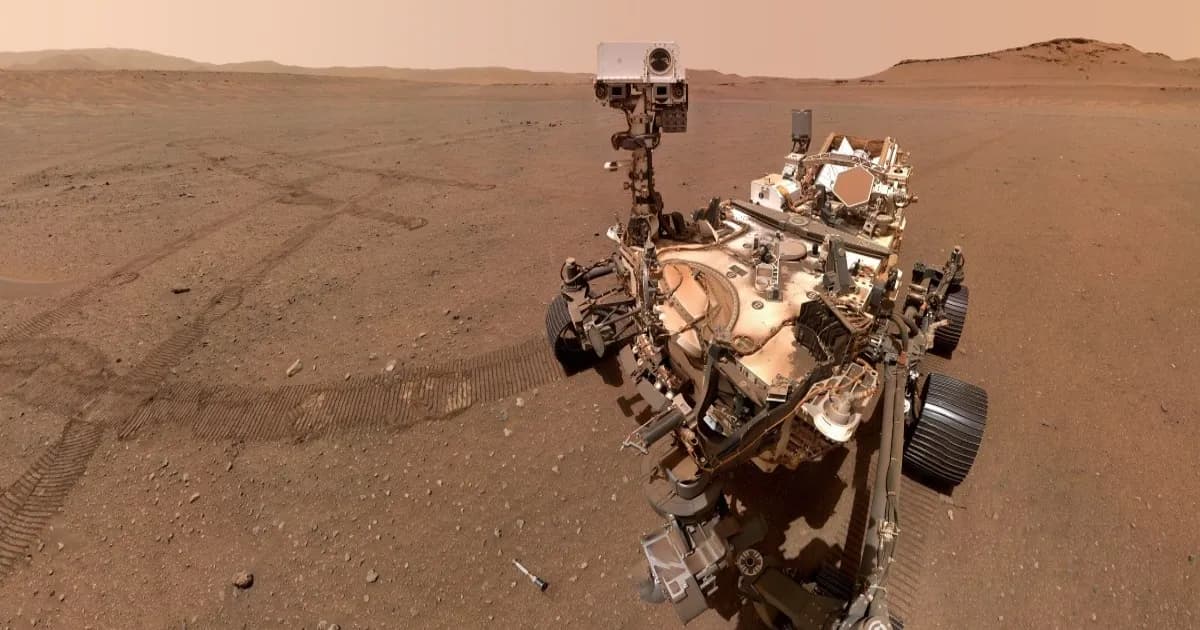 Rover Perseverance NASA menjelajahi permukaan Mars dengan latar bebatuan merah dan langit berdebu.