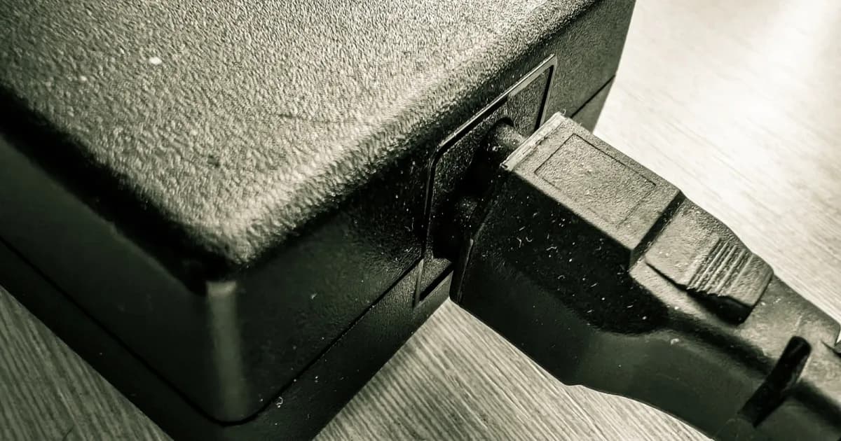 Ilustrasi charger laptop besar dan kecil berdebu