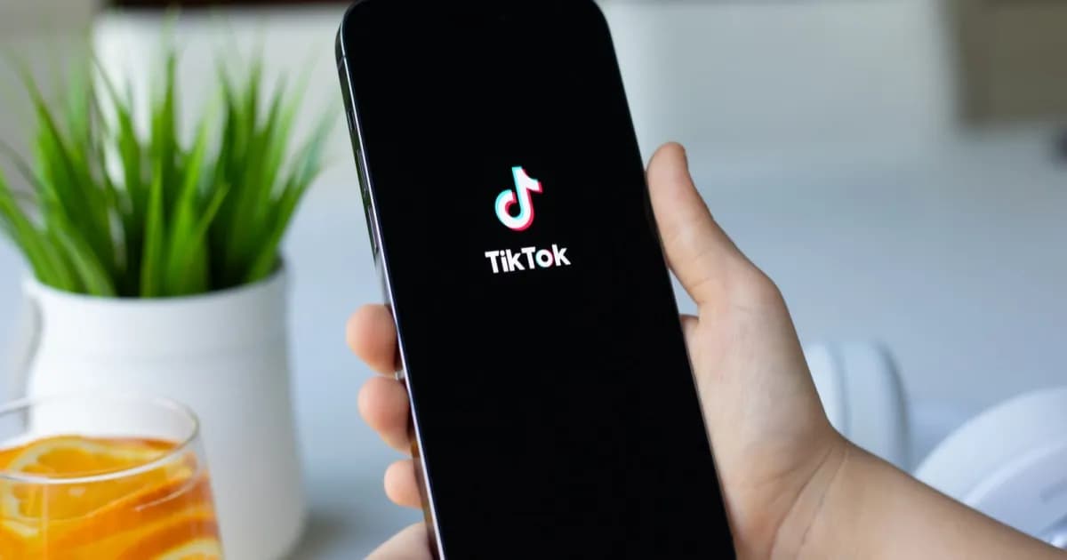 Aplikasi TikTok sedang dimuat di iPhone 15 Pro dengan latar belakang warna-warni