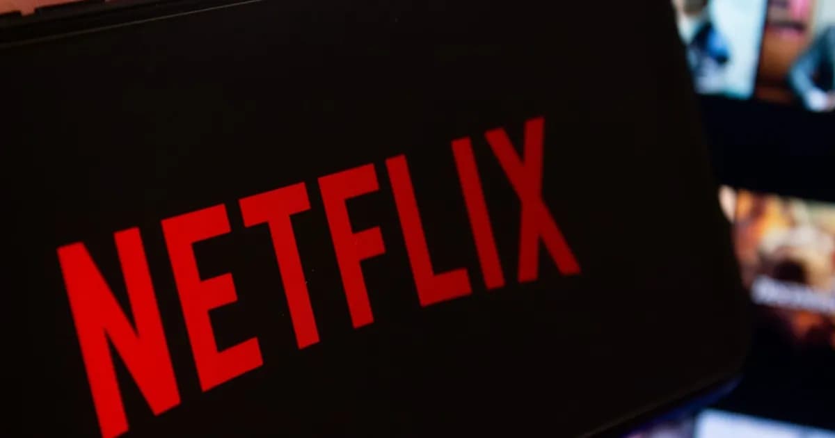Tampilan smartphone dengan logo Netflix dan layar besar menampilkan thumbnail konten di latar belakang