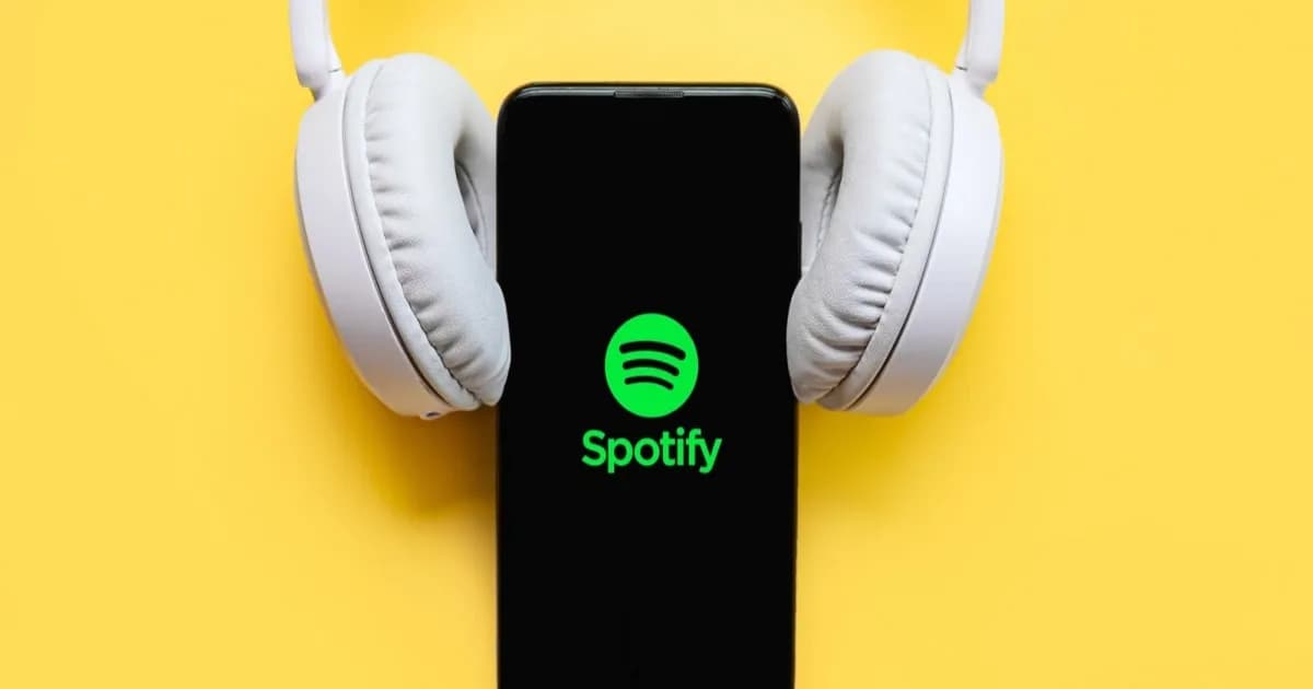 Ilustrasi logo Spotify dengan headphone putih di atas ponsel