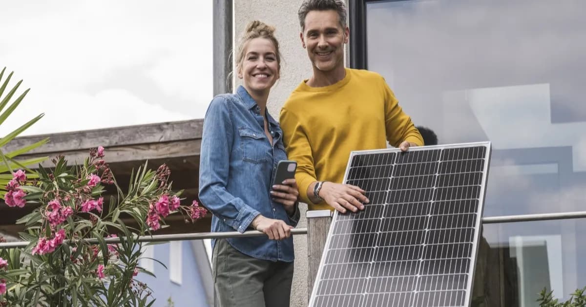 Pasangan memasang panel surya plug-in di balkon rumah