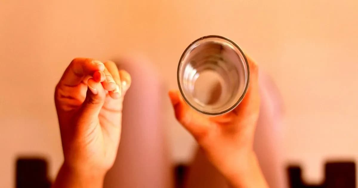 Ilustrasi seorang wanita meminum obat dengan segelas air, terkait kasus gugatan terhadap OpenAI.