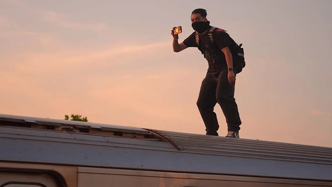 Subway surfer di atap kereta 7 line New York City yang merepresentasikan dampak konten media sosial berbahaya