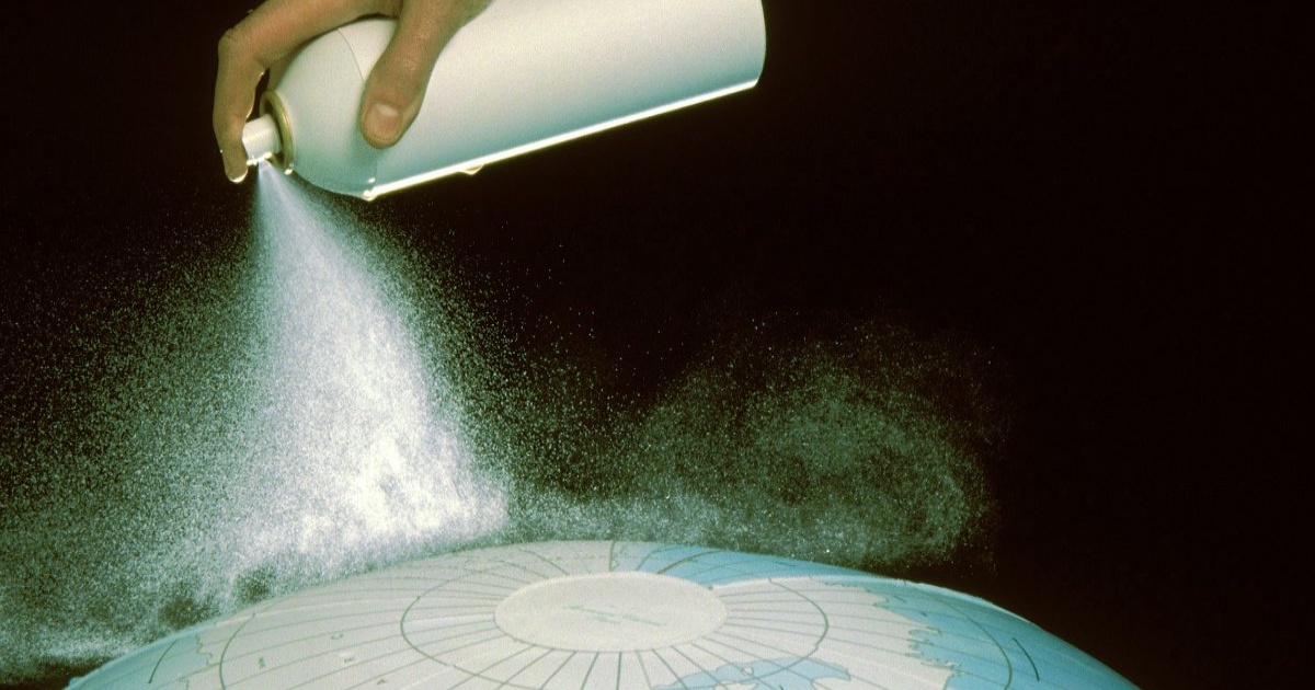 Ilustrasi tangan menyemprotkan aerosol ke globe Bumi dari kutub selatan, melambangkan eksperimen geoengineering yang tidak terkendali