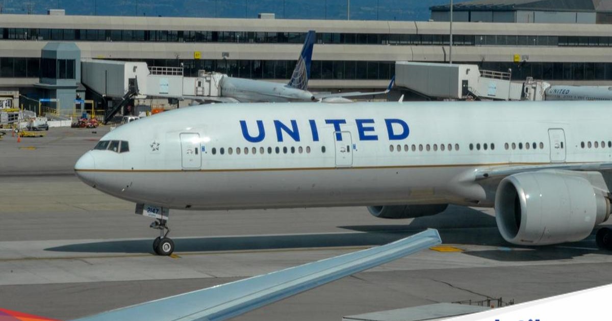 Ilustrasi pesawat United Airlines Boeing 777-300 yang terbang di atas awan