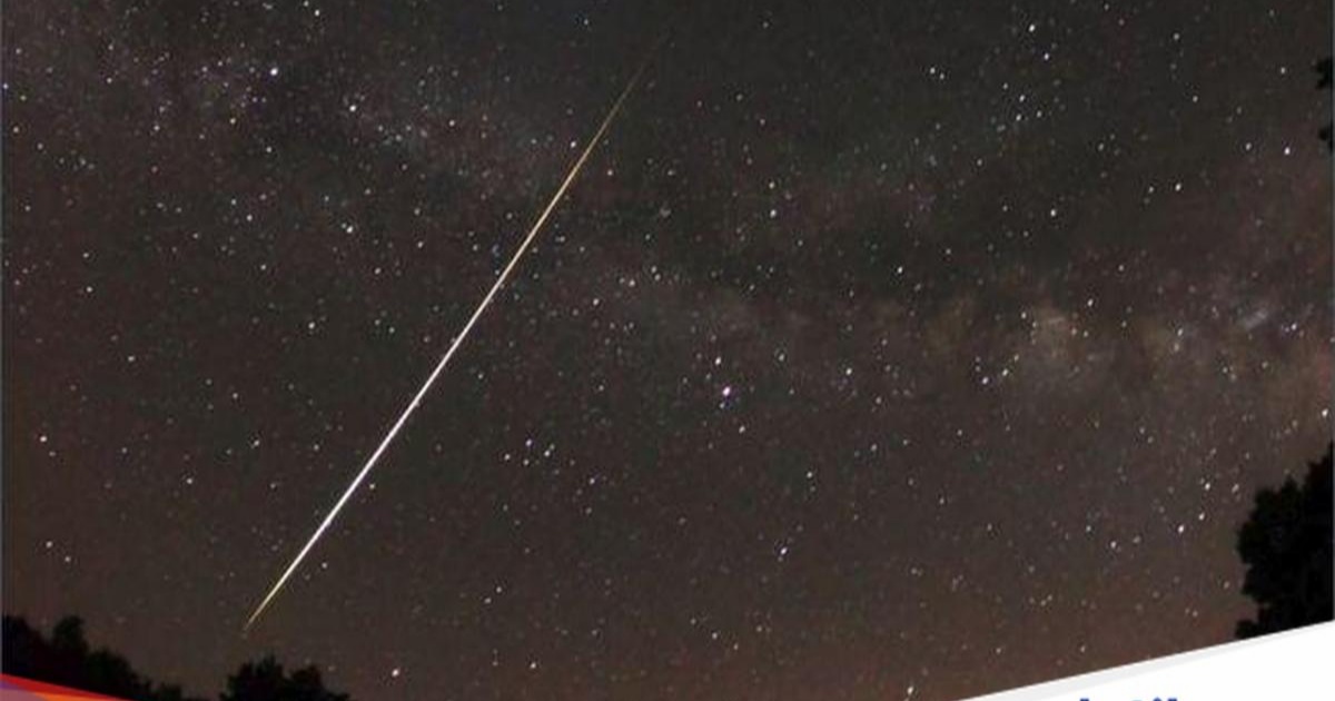 Ilustrasi hujan meteor dengan bola api terang melintas di langit malam