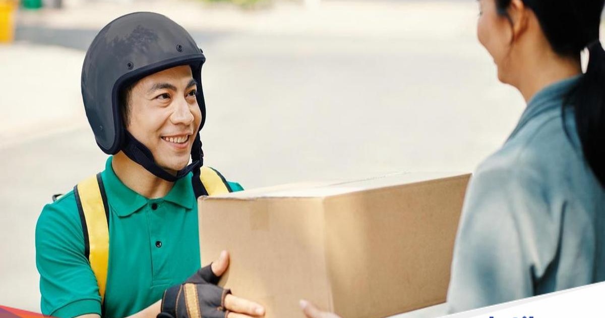 Ilustrasi seorang kurir online sedang mengendarai sepeda motor sambil membawa paket di jalan raya perkotaan.