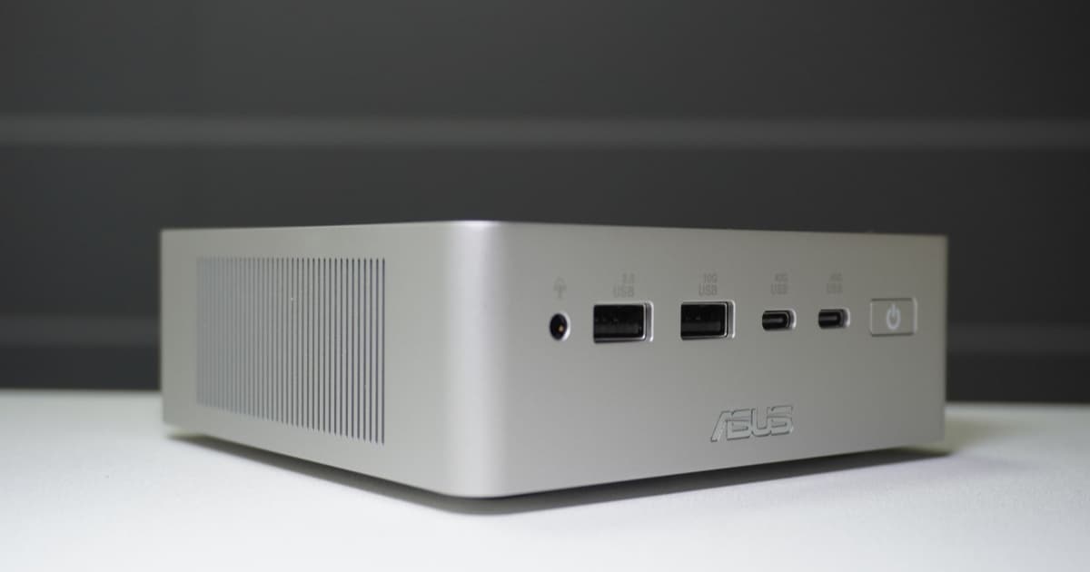Asus Ascent QN10 mini PC dengan casing perak aluminium anodized di atas meja kayu