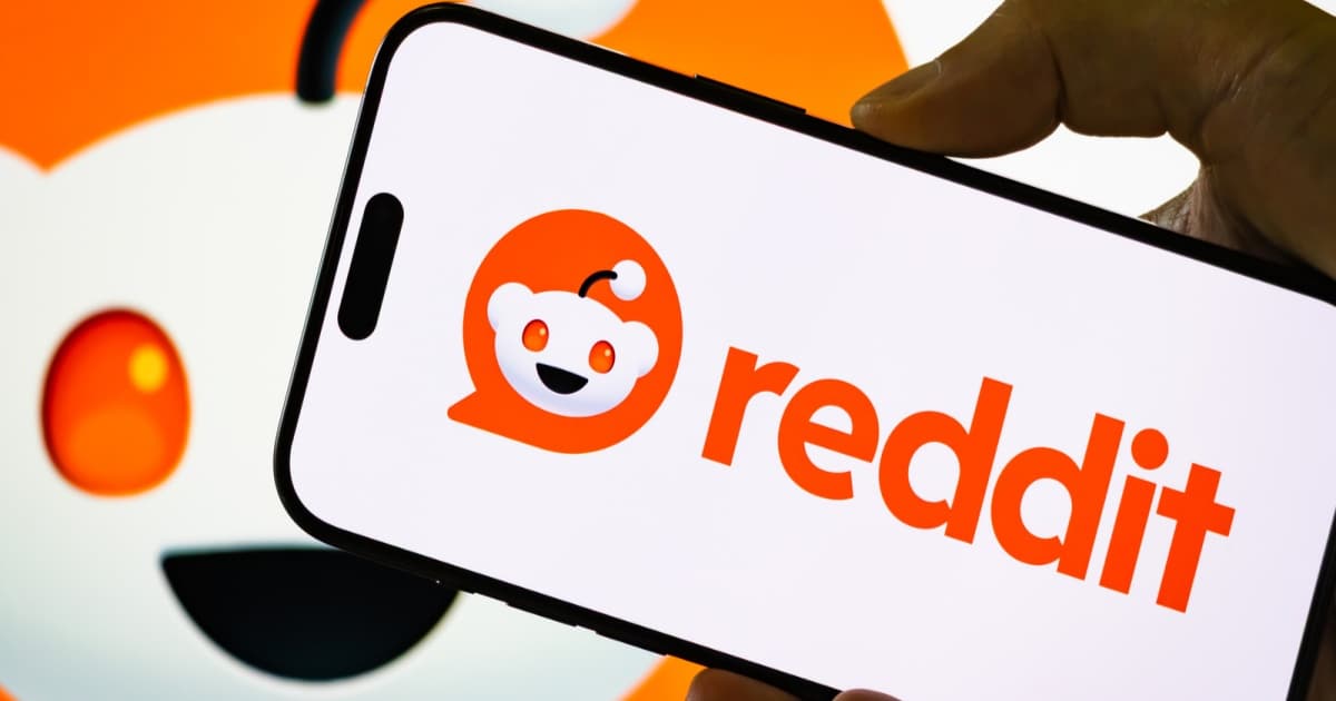 Logo Reddit di layar ponsel dengan latar belakang merah