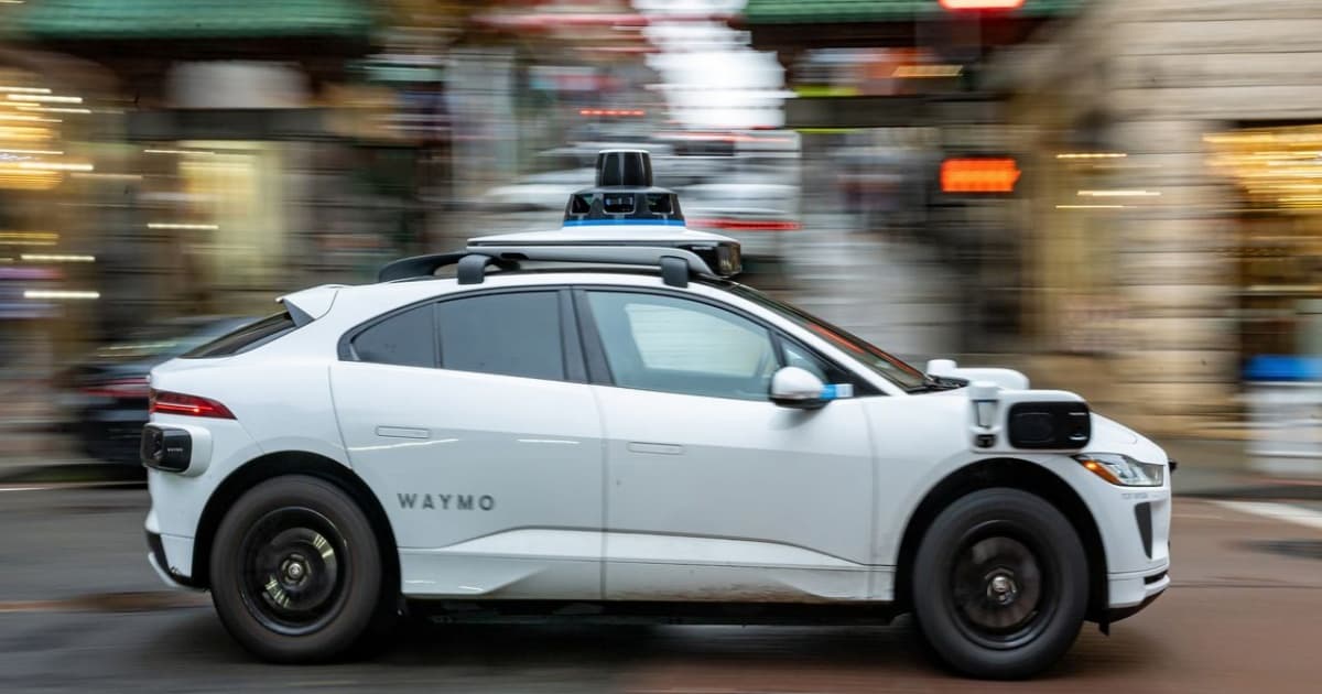 Robotaxi Waymo di jalan bebas hambatan dengan rambu zona konstruksi