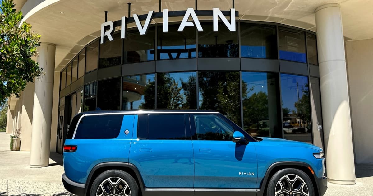 Mobil listrik Rivian R1T berwarna biru di depan showroom