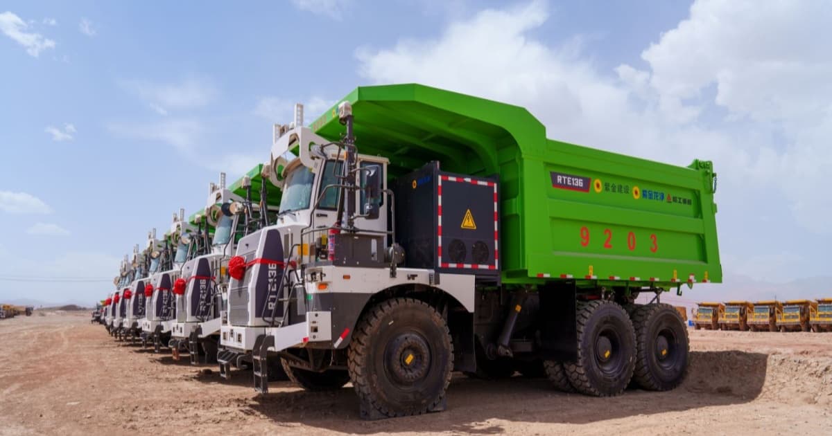 Armada truk tambang listrik LK220E Zijin Mining beroperasi di tambang seng Wulagen, Xinjiang, China