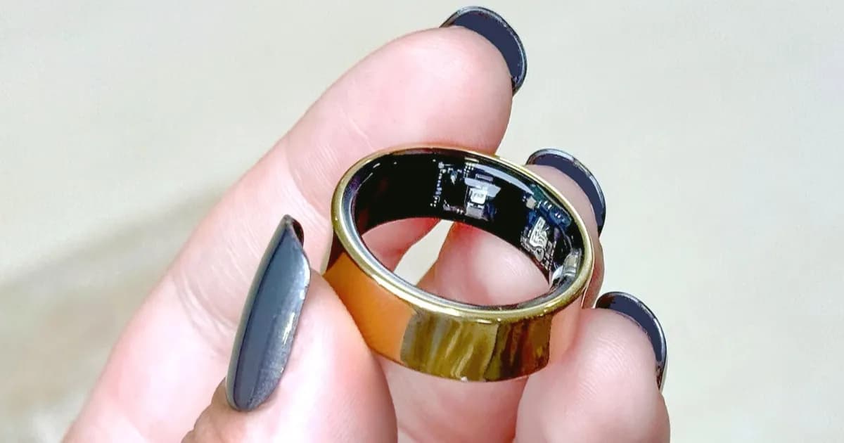 Samsung Galaxy Ring di tangan pengguna dengan latar belakang taman