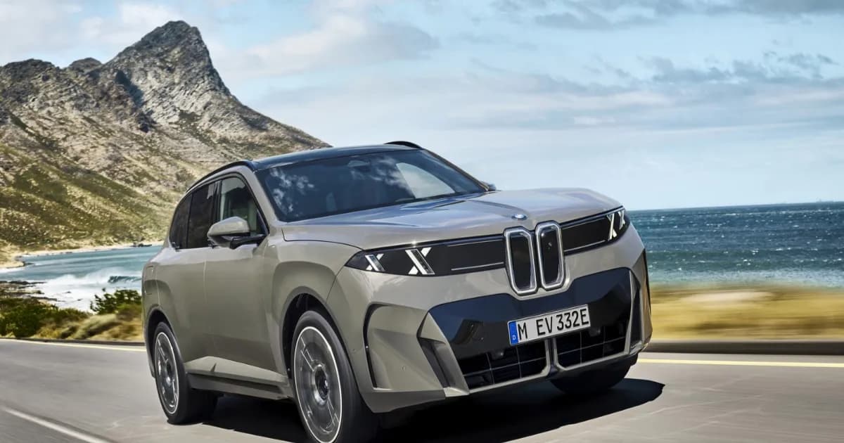 BMW iX5 60 xDrive berwarna abu-abu dipamerkan di jalan pesisir yang kering dengan latar langit biru