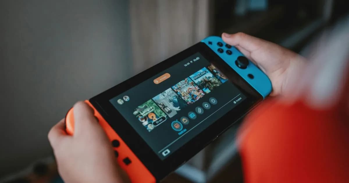 Seseorang memegang konsol Nintendo Switch