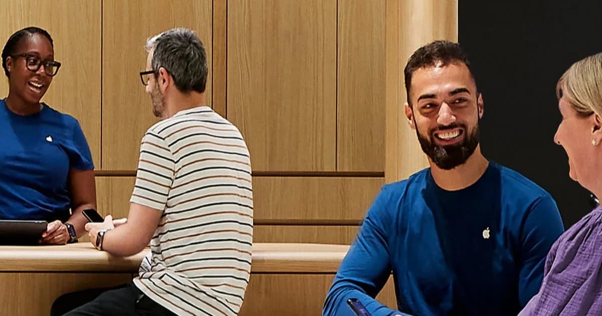 Apple Store specialist showing a customer an iPhone at Genius Bar