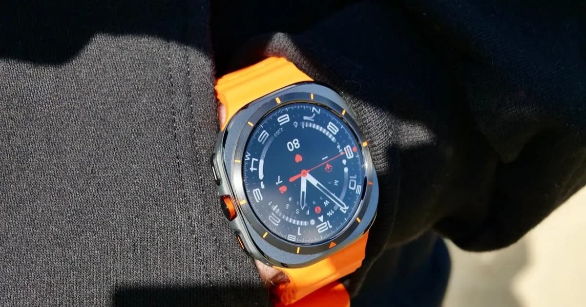 Galaxy Watch Ultra 2 tampak depan dengan tali hijau olive dan cincin oranye di crown