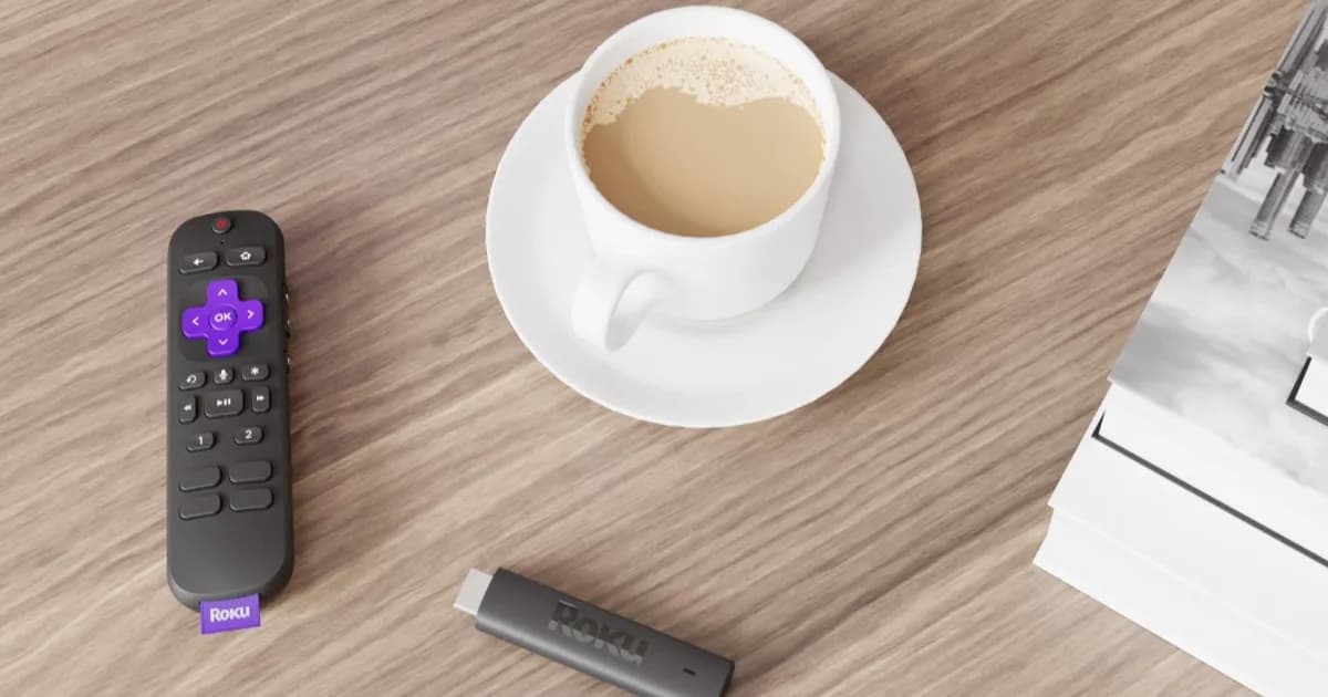 Roku Streaming Stick 4K dengan remote kontrol di atas meja kayu