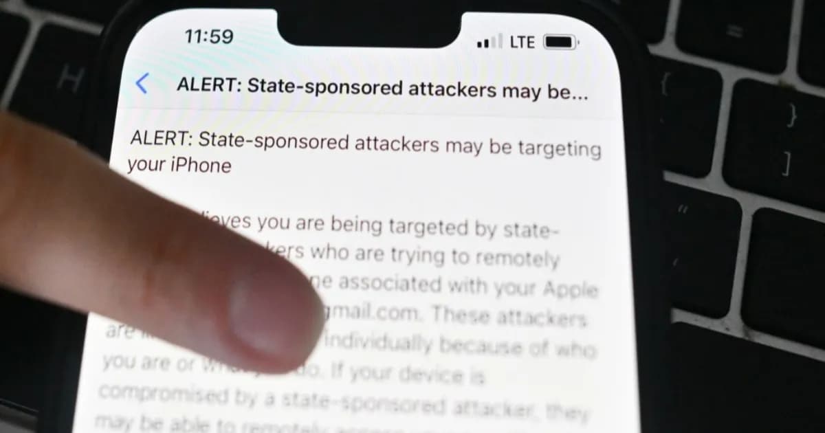Ilustrasi notifikasi peringatan spyware Apple di layar iPhone dengan latar belakang keamanan siber