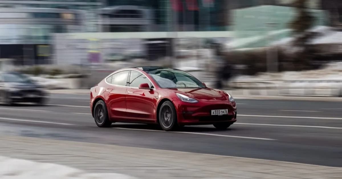 Mobil Tesla merah melaju di jalan raya saat uji sistem Full Self-Driving yang nyaris mengalami kecelakaan