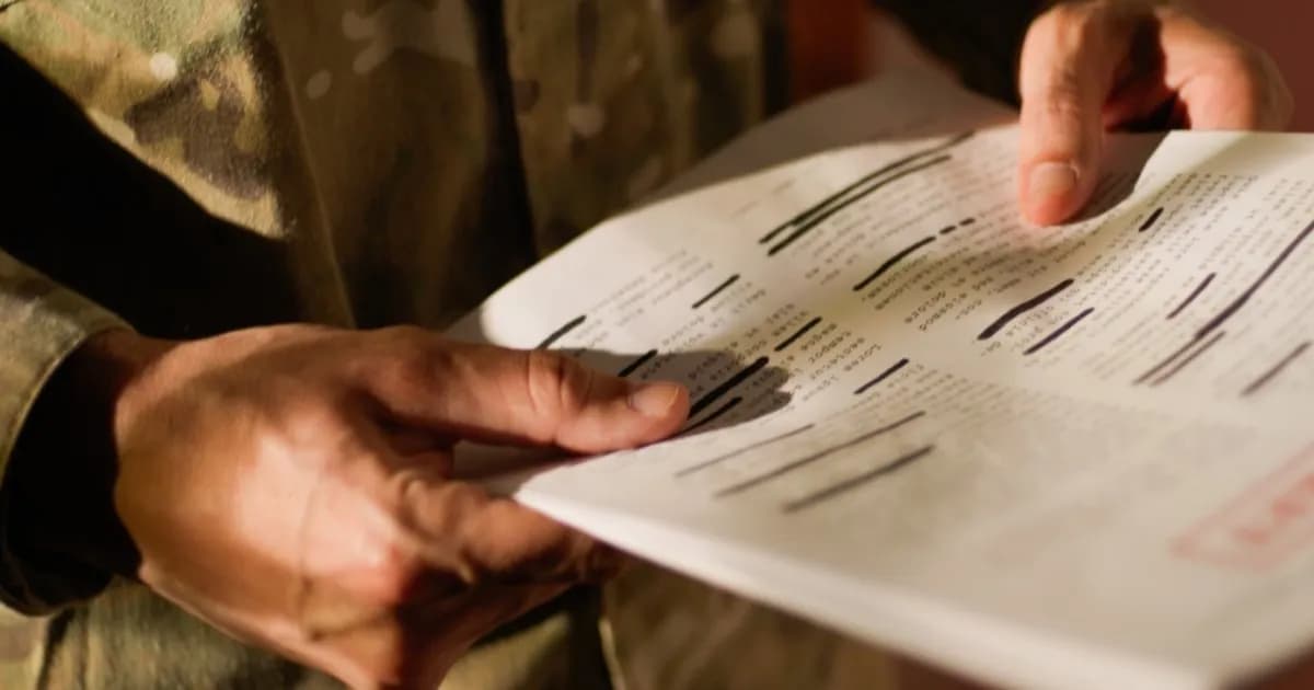 Tangan memegang dokumen rahasia dengan baris teks yang disensor, mengenakan seragam kamuflase, ilustrasi kebocoran informasi militer di Polymarket