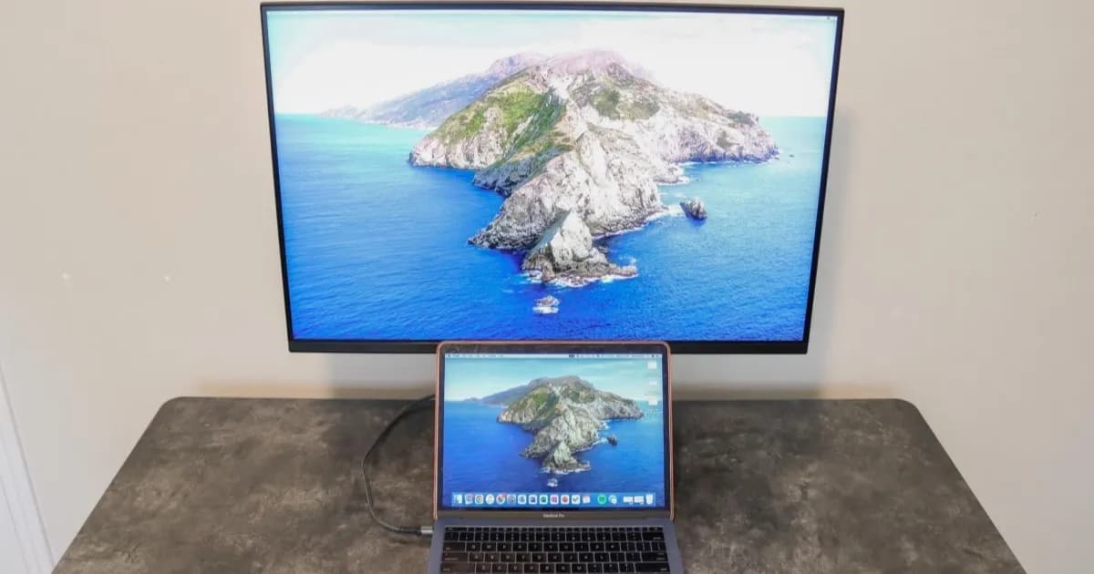 MacBook Pro terhubung ke Samsung M7 Smart Monitor melalui kabel USB-C tunggal di meja kamar kos