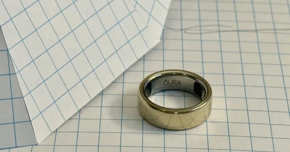 Oura Ring yang sedang digunakan di jari tangan dengan latar belakang kamar tidur