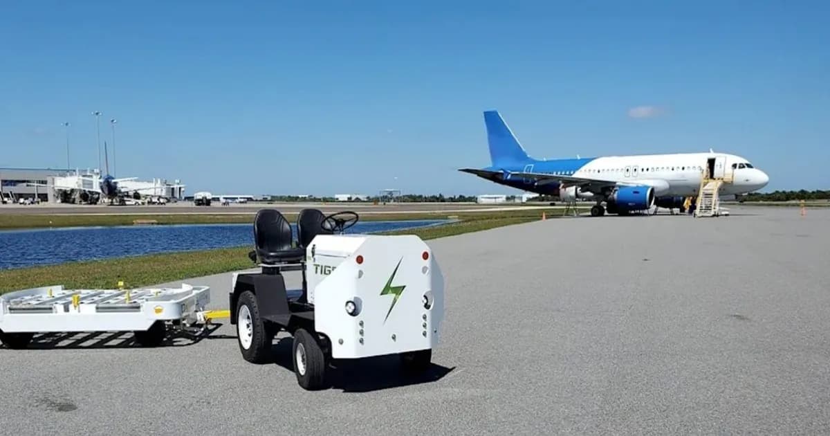 Traktor bagasi listrik Tiger Li-Ion dengan kapasitas tarik 60.000 lb di area tarmac bandara