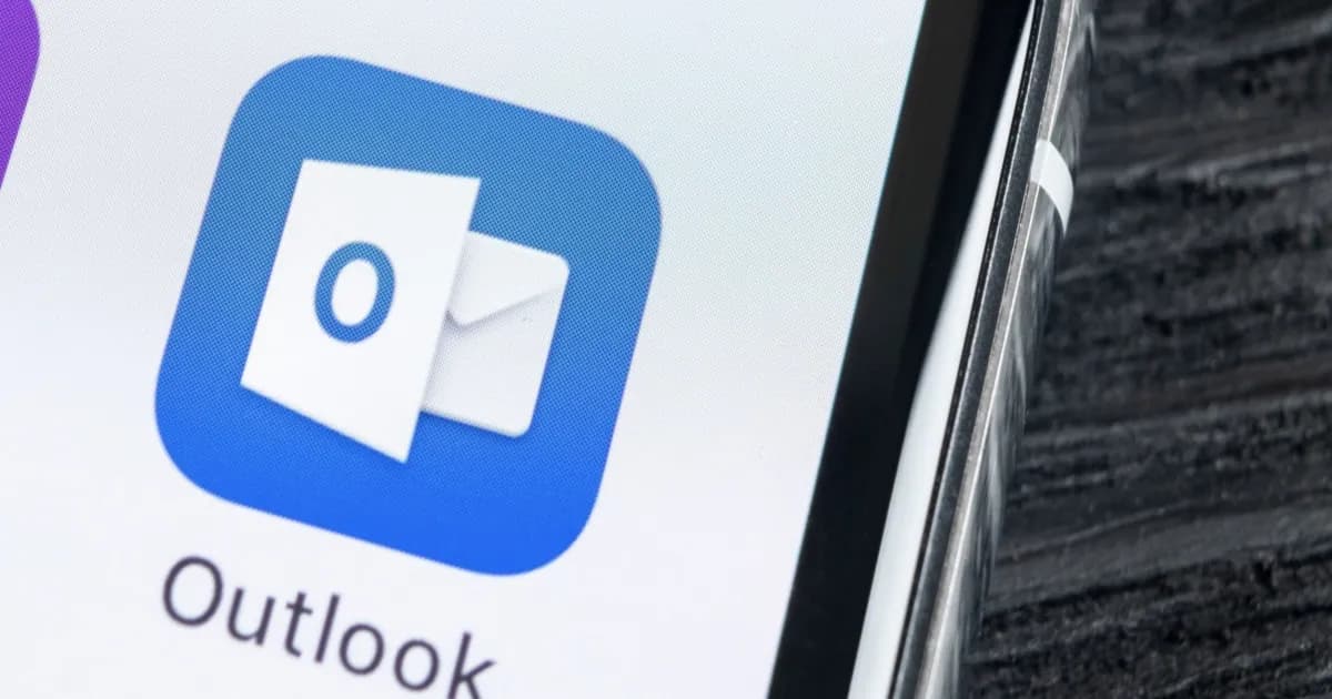 Ilustrasi layar komputer yang menampilkan logo Microsoft Outlook dengan indikator gangguan