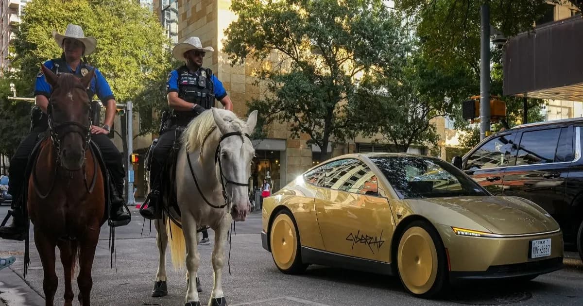 A Tesla Cybercab passes Austin Police Department officers on horses on 2nd street outside ACL Live.
