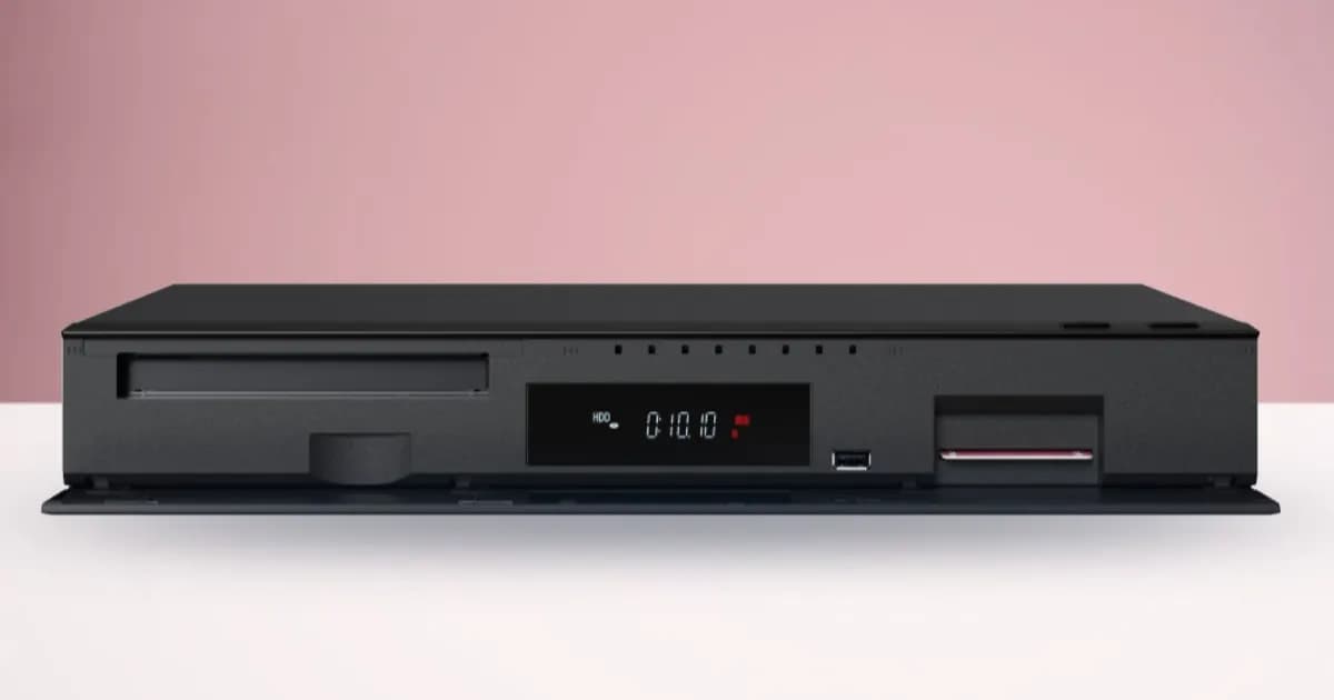 Pemutar Blu-ray Panasonic DMR-4X1010 berwarna hitam di atas permukaan putih dengan latar pink