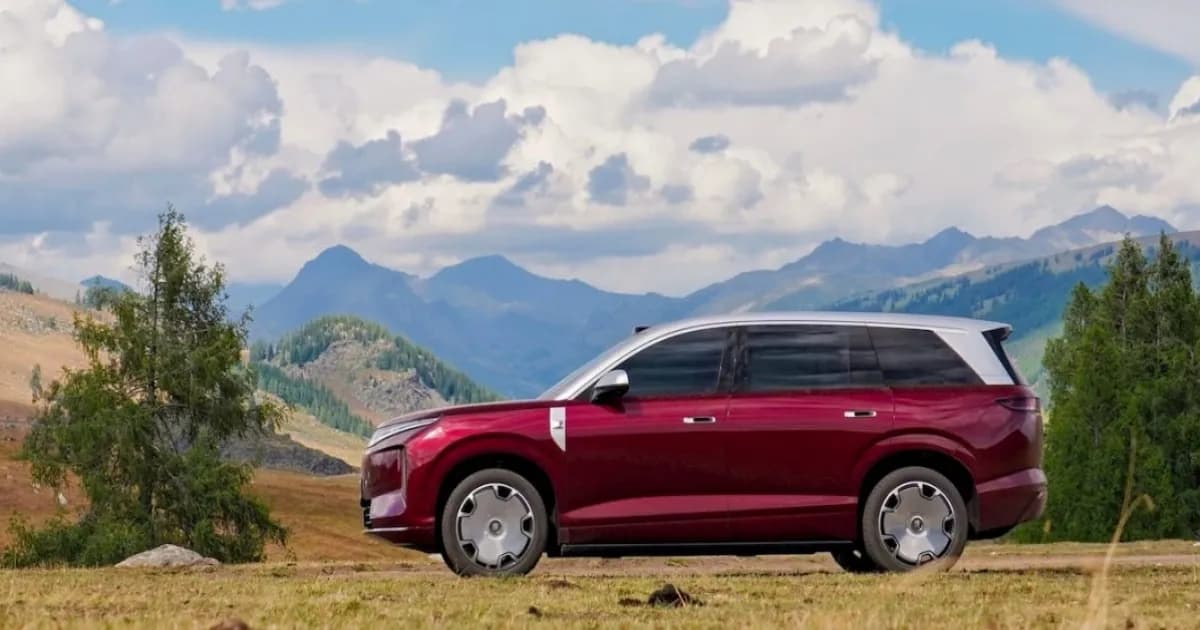 SUV listrik flagship BYD Great Tang berwarna gelap tampak dari samping dengan latar jalanan kota