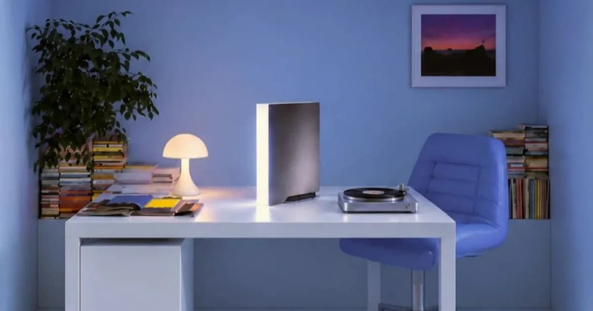 Ghost Core AI PC sat on a table in a home office, next to a record player and lamp