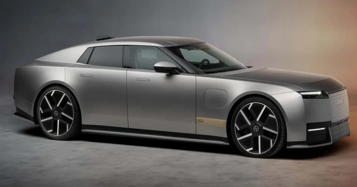 Jaguar Type 01 EV empat pintu warna netral dengan velg 23 inci dan kap mesin panjang di jalan perkotaan