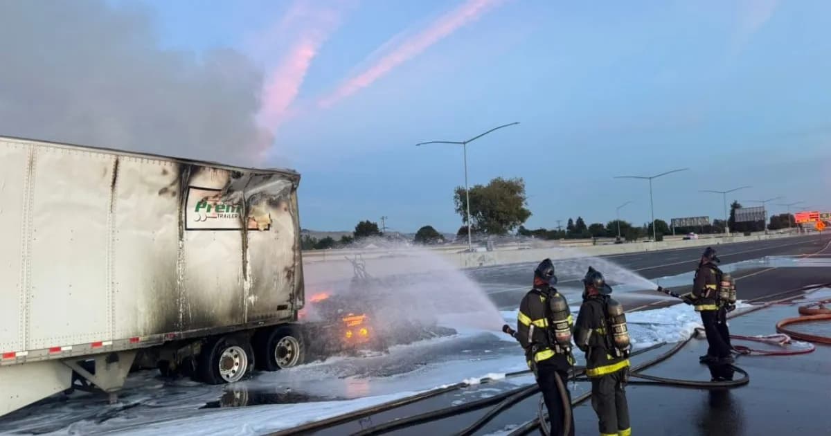 Petugas pemadam menyemprotkan busa ke Tesla Semi dan trailer yang terbakar di I-880 Hayward, California