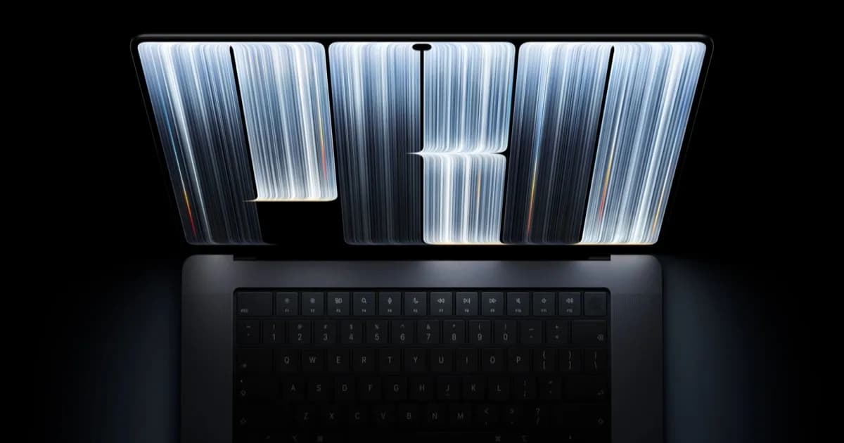 MacBook Pro OLED dengan layar PROLED XDR dan logo Apple menyala di atas meja kerja