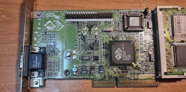Vintage ATI graphics card on wooden surface, showing detailed microchip design and layout.