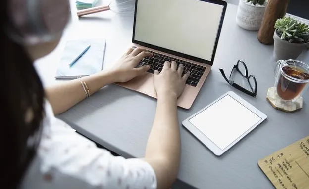 Business owner with headphones working at laptop