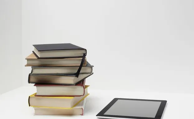 Stack of books with digital tablet
