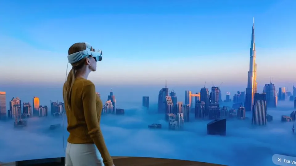Seseorang menggunakan headset Vision Pro Apple melihat panorama virtual kota di awan